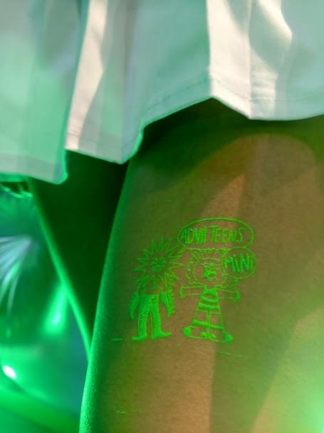 Tatuaje temporal de serigrafía fluorescente aplicado en el brazo de un asistente